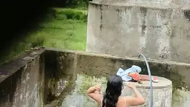Indian village girl bathing near water tank outdoor