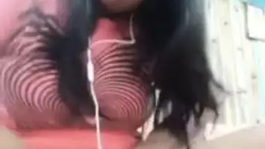 Smiling Indian with glasses listens to music and undresses at once