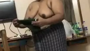 Fat Indian woman with big belly walks around the house with naked boobs