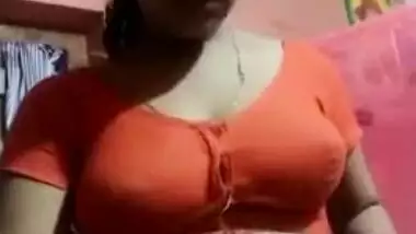Aroused Desi wife slowly takes red top off to expose boobs for XXX fans